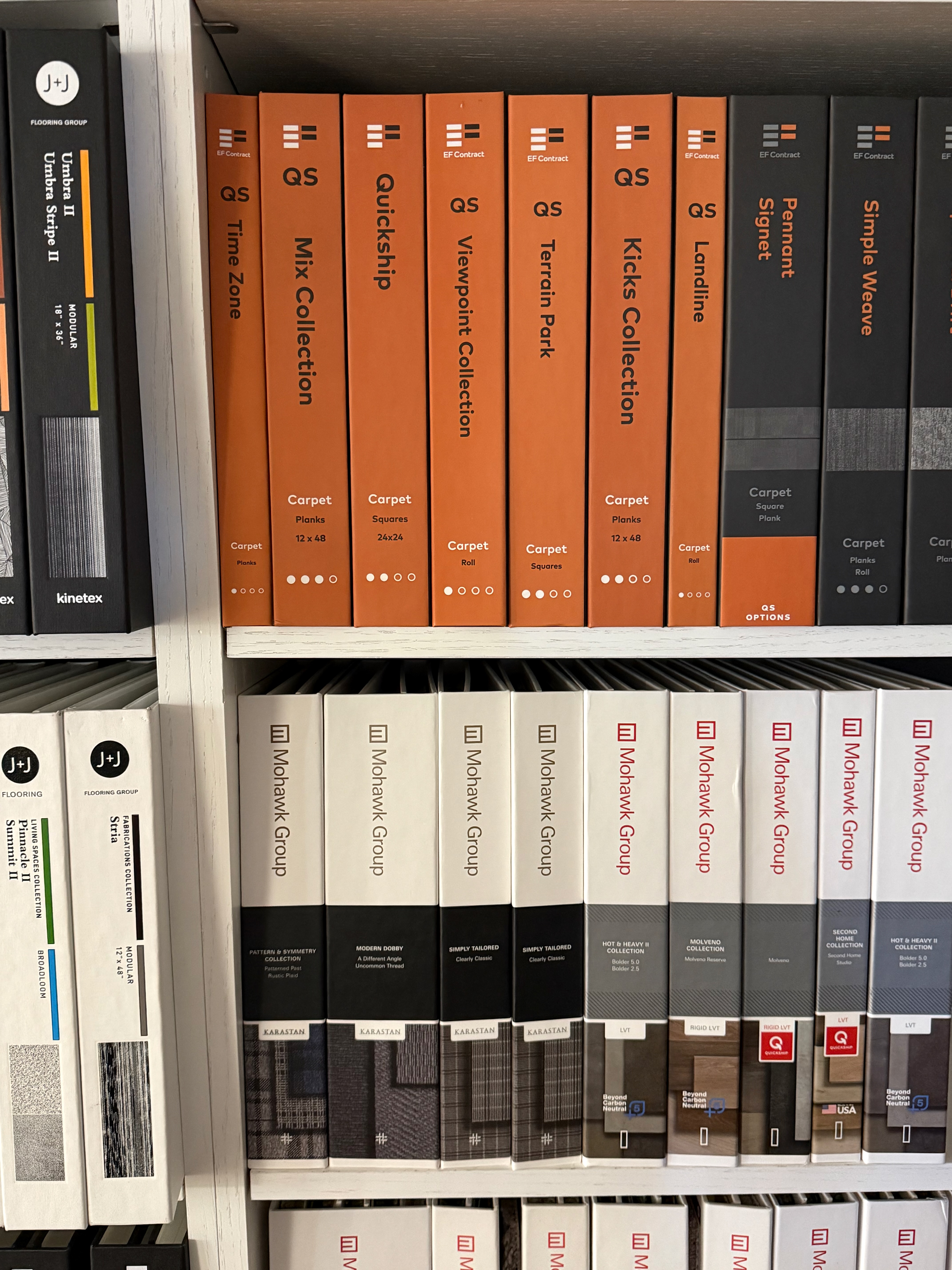 The carpet binder library inside the Naples showroom — Stanton, Mohawk, and J+J samples