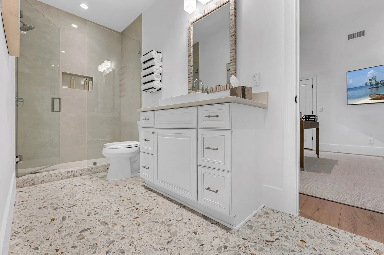 A finished Naples guest bath with large-format porcelain shower walls and a terrazzo floor