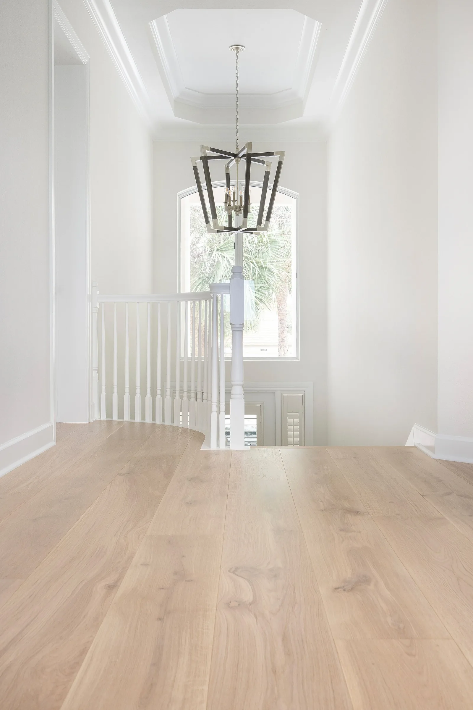 Entry & stair. A curved stair in a soaring, bright foyer.